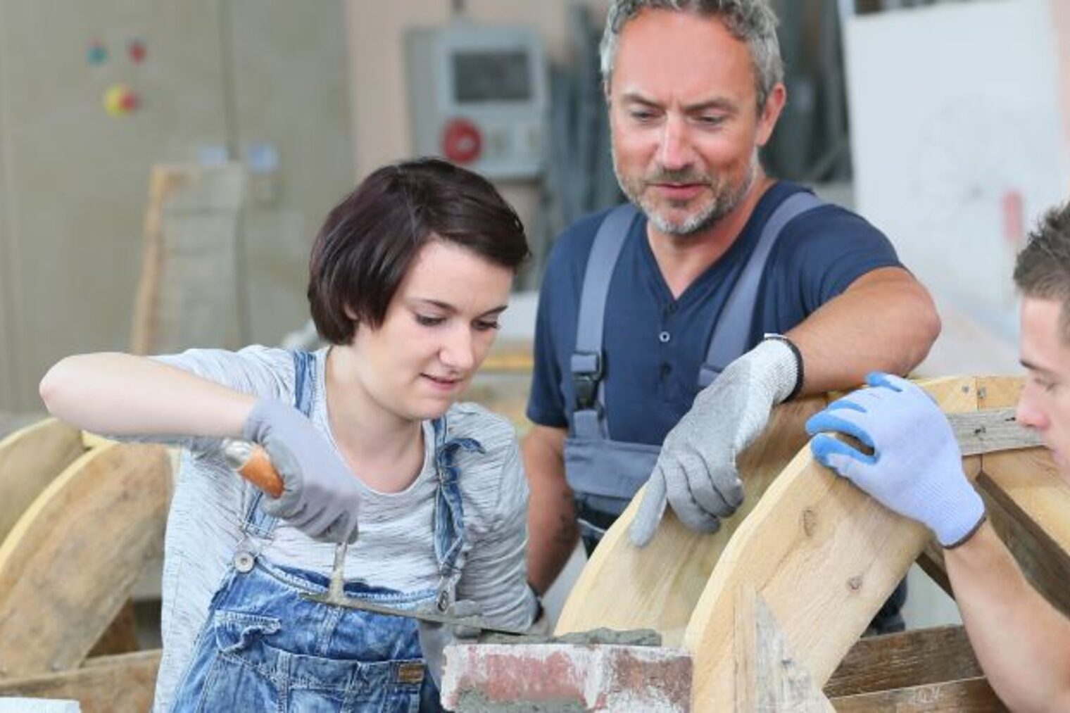 Ausbilder zeigt Azubis wie man mauert