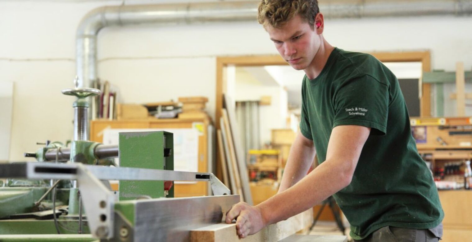 Eine Person arbeitet an einer Werkbank in seiner Werkstatt.