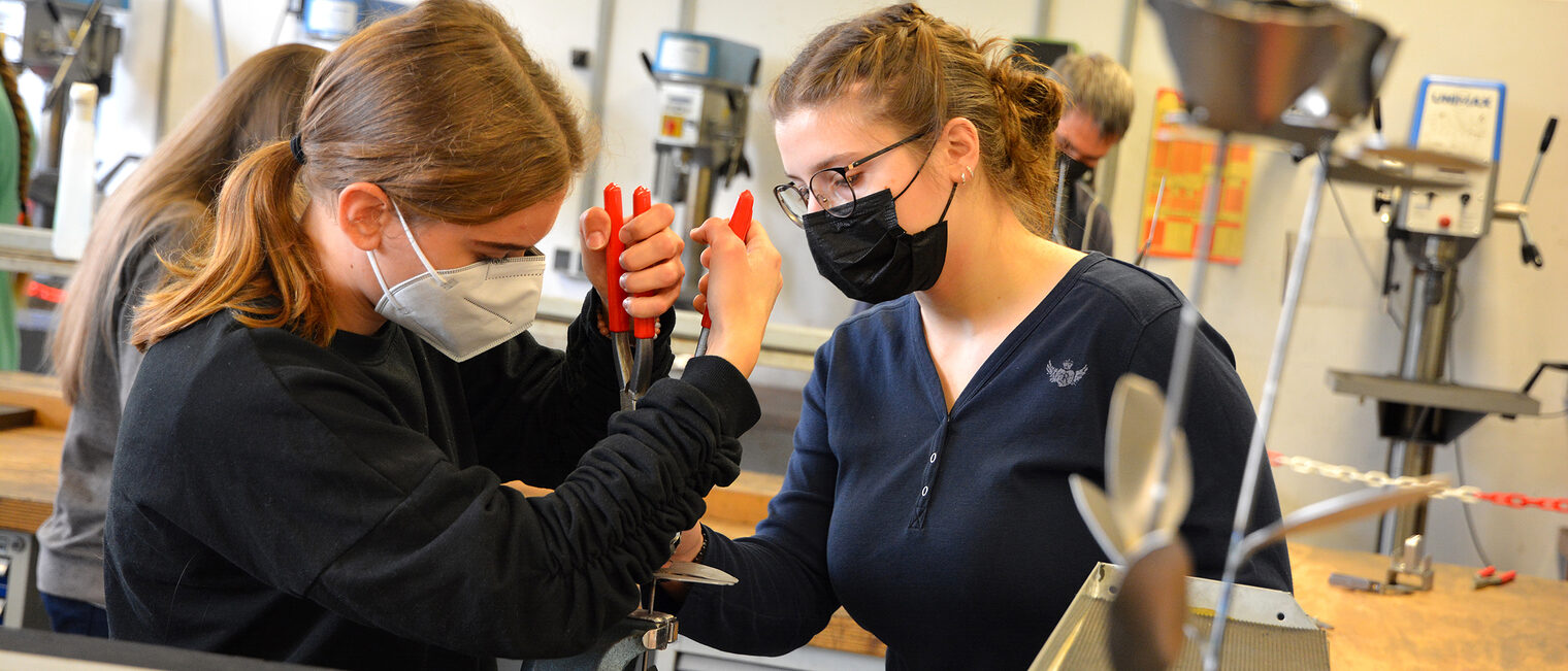 Was entsteht wohl bei diesen beiden jungen Handwerkerinnen? Wer genau hinsieht, wei&szlig; es.