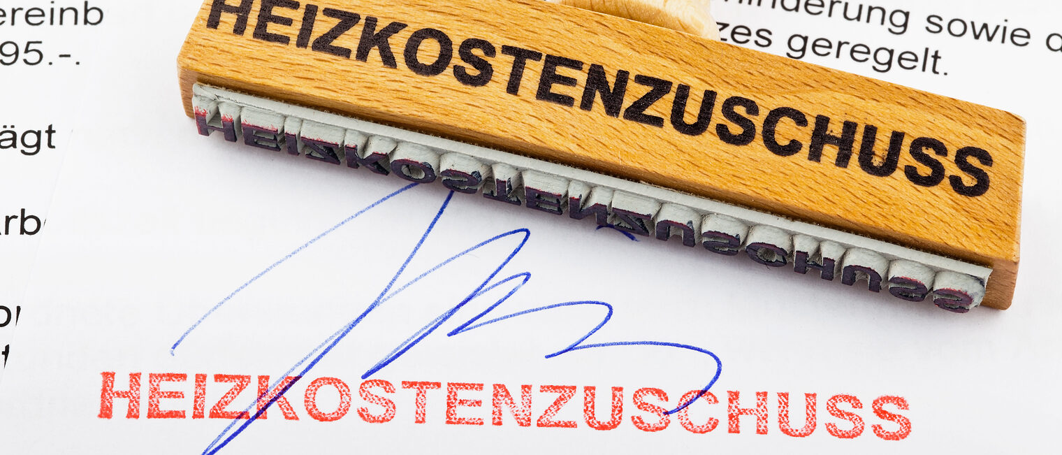 Ein Stempel aus Holz liegt auf einem Dokument. Deutsche Aufschrift: Heizkostenzuschuss Schlagwort(e): Stempel, Holzstempel, Heizkostenzuschuss, Zuschuss, Förderung, Fördermittel, Heizung, Heizen, Heizkosten, Kosten, Verbrauch, Energieverbrauch, Heizkörper, Energiepreis, Energiepreise, Energieversorgung, Gaspreis, Gasheizung, Ölheizung, Ölpreis, Erdgas, Preis, Heizungskosten, Wärmedämmung, Fernwärme, Öl, Erdöl, Betriebskosten, Gas, Ferngas, Wirtschaft, Energie, Rohstoffe, Energiekosten, Energiebedarf, Energiewirtschaft, Energiebranche, Sozialhilfe, Soziales, Arm, Armut, Hartz IV, Hartz-IV, Mindestrentner, Armutsfalle, Notstand, Mindestpension, Sozialpolitik