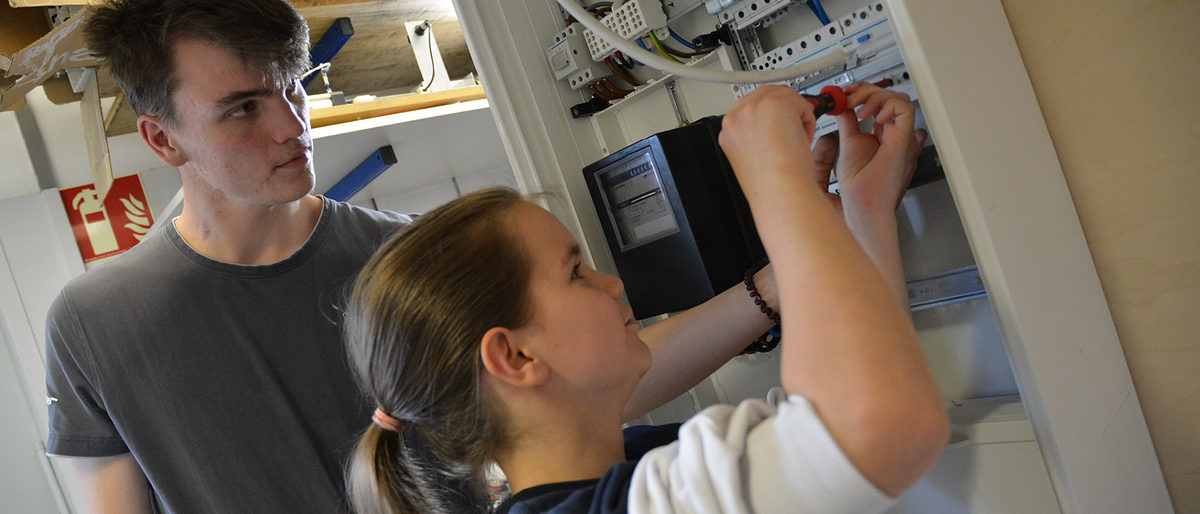 Ein gutes Team: Elektrotechniker-Azubi Christian gemeinsam mit Schülerin Elli in der Elektrowerkstatt im BBZ. Ein gutes Team: Elektrotechniker-Azubi Christian gemeinsam mit Schülerin Elli in der Elektrowerkstatt im BBZ.